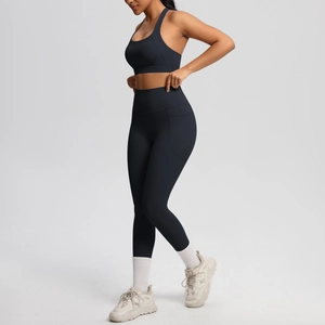 Detail of high-waisted black yoga leggings with side pockets and racerback sports bra