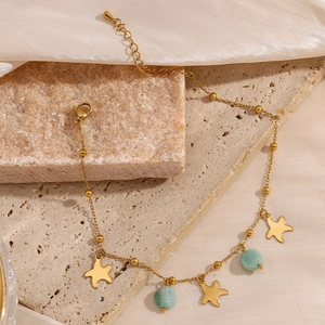 Cavigliera dorata con stelle e perline di amazzonite su sfondo in seta minimalista