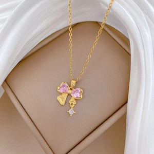 Dettaglio del ciondolo a fiocco con zircone rosa su catena in acciaio al titanio oro
