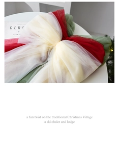 Close-up of red, green, and cream tulle bow decoration for festive Christmas tree topper