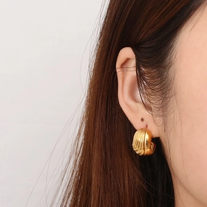 Modern gold shell rib texture earrings on model for a vintage minimalist aesthetic look