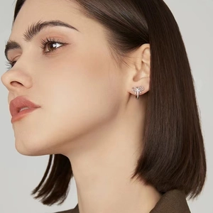 Elegant s925 silver bow stud earrings on a female model with a minimalist backdrop