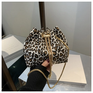 Primer plano detallado de un bolso bombonera con estampado de leopardo y cadena dorada fina