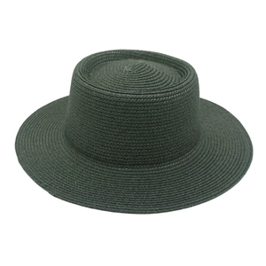 Detail of dark green straw hat featuring flat top and wide brim in woven texture