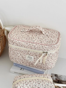 Close-up of quilted floral makeup bag with pink flower pattern and soft handle detail