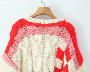 Détail de la maille torsadée sur un pull au crochet fait main à col en V rouge et rose