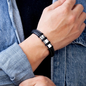 Fashionable black braided leather bracelet with silver metal clasp on male model wrist