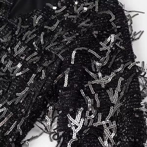 Detailed macro view of black sequin dress featuring shimmering fringe and elegant texture