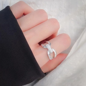 Elegant silver interlocking U-shape ring with pavé small diamonds and baguette stones
