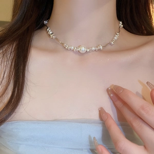 Detail of silver pearl necklace with irregular metal beads on a model's collarbone
