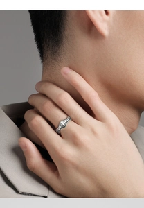 Close-up of vintage silver ring with intricate embossed texture on male model hand