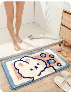 Close-up of plush absorbent bathroom mat with cute cartoon rabbit on wooden floor