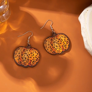 Leopard print pumpkin earrings with metal hooks on autumn harvest style background