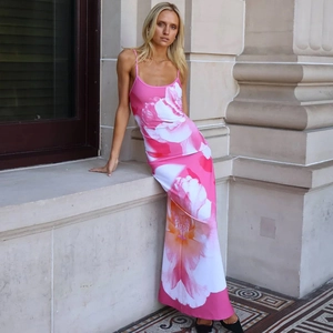 Detail of pink floral print on a long backless sundress with side slit and flowy material