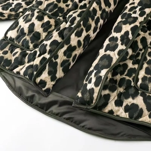 Detail of leopard print quilted jacket featuring deep green lining and functional pockets