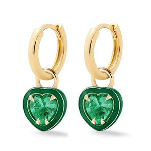 Close-up of golden hoop earrings featuring green enamel heart charms with center gemstones