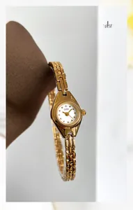 Macro d'une montre dorée GEDI pour femme montrant le cadran poli et le bracelet métallique