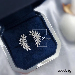 Silver leaf-shaped earrings with cubic zirconia in a blue velvet jewelry box