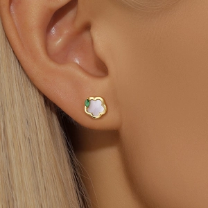 Close-up of a floral S925 silver stud earring with white petal and green gemstone on ear