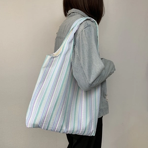 Détail du cabas en toile rayée bleue et blanche avec une texture gaufrée seersucker