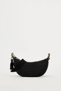 Detail of black woven crescent bag featuring a textured pattern and wide fabric strap