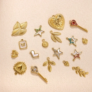 Assorted gold stainless steel charms including stars and hearts on a beige background
