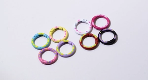 Detail view of 8 colorful polka dot round spring O-rings for DIY keychains and crafts