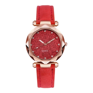 Detail of red starry dial watch with rose gold faceted case and matte leather strap