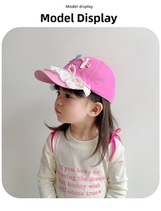 Detailed side view of pink cotton kids baseball cap with lace trim and pearl bow