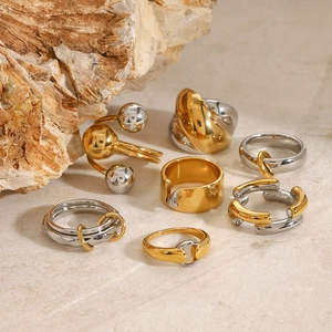 Minimalist gold and silver two-tone stainless steel rings on a natural stone base