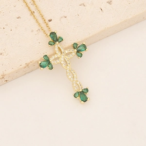 18K gold plated copper cross necklace with zircon and green teardrop stones on stone