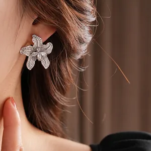 Ohrstecker Silber Blume mit Zirkonia an Modell vor dunklem Hintergrund präsentiert