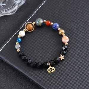 Macro view of solar system planetary beads and gold Cancer zodiac charm bracelet