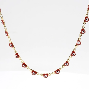 Close-up of gold 18K titanium chain with a red evil eye heart pendant on white background