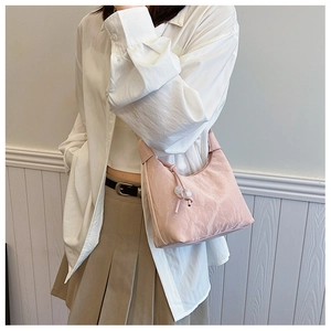 Pink hobo shoulder bag with pleated texture and decorative beads shown on model