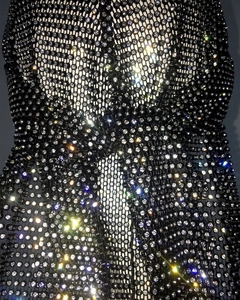 Macro shot of high-density rhinestone inlay on black mesh fabric showing brilliant sparkle