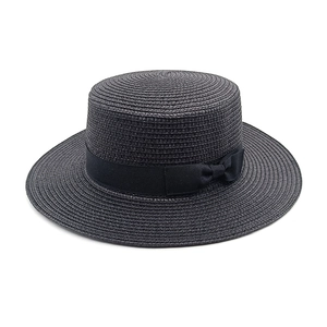Detailed view of the fine straw weave and black grosgrain ribbon on the flat top boater hat