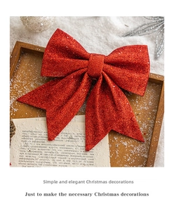 Sparkling red sequin Christmas bow decoration on wood tray with faux snow and pine cones