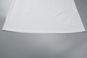 Détail du tissu blanc gaufré et de la couture de l'ourlet plat de la robe ajustée
