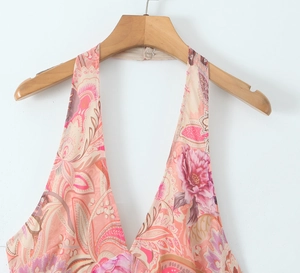 Detail of pink halter neck dress with intricate paisley patterns and deep V-neckline