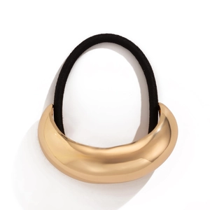 Detail of high-elastic black hair band with a polished crescent-shaped gold metal charm