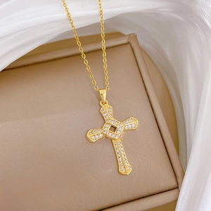 Detail shot of golden spinning cross necklace with inlaid crystals on elegant jewelry box