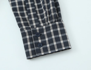 Detail of plaid shirt cuff with dark buttons and visible cotton linen fiber texture