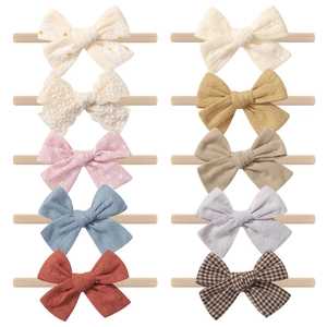 Set of 10 assorted baby bow headbands featuring floral patterns and solid textures