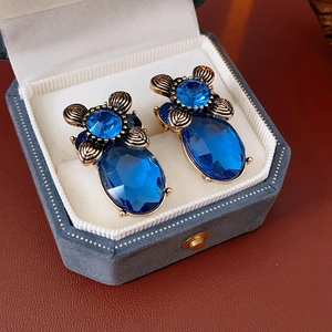 Details von Vintage-Goldohrringen mit tiefblauen ovalen Edelsteinen auf Lederuntergrund