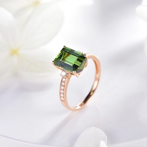 18K rose gold ring featuring emerald-cut green tourmaline and sparkling side diamonds