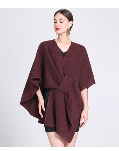 Detail of burgundy knitted poncho cape with front knot design and asymmetric hemline