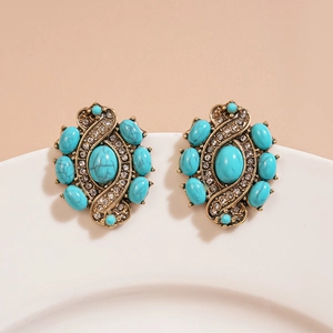 Gros plan de boucles d'oreilles fleur or rétro avec pierres turquoise et strass brillants