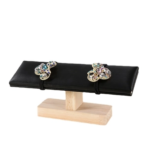 Bow-shaped hair ties with colorful rhinestones on a black velvet jewelry display stand
