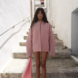 Detailansicht der rosa Wildlederimitat-Jacke mit Stehkragen und dunklem Knopfverschluss
